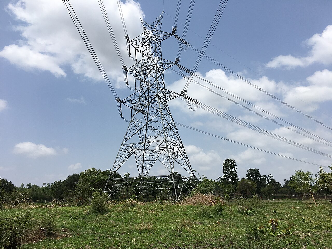 High-voltage transmission tower carrying power lines across fields in Maharashtra